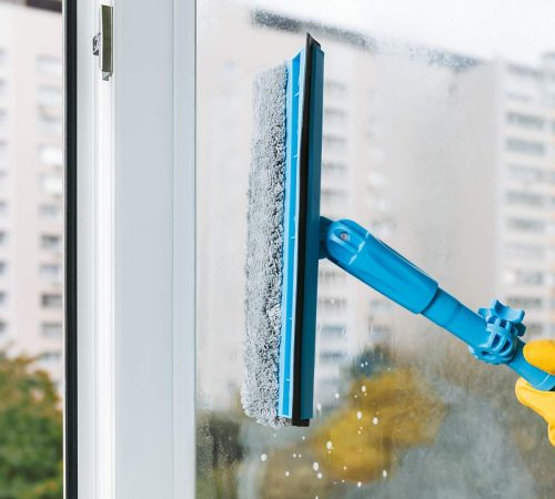 man-in-yellow-rubber-gloves-cleaning-window